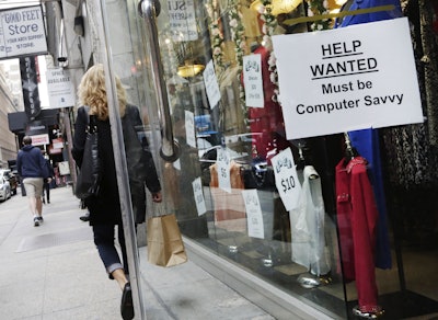 In this Oct. 1, 2015, file photo, a shopper walks past a store with a 'Help Wanted' sign in the window, in New York. (AP)