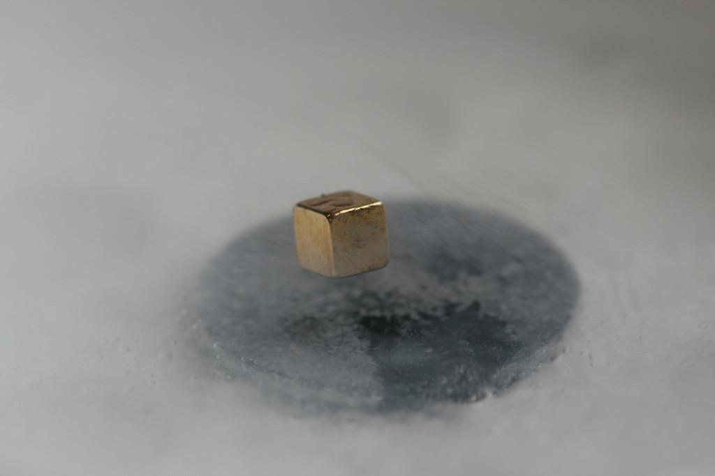A metal cube levitating over a superconducting magnet. (Image credit: Getty Images via GE Reports)