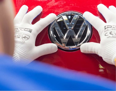 A worker checks the Volkswagen sign on a Golf car during the so called 'Open Door Day' to celebrate the 25th anniversary of the German manufacturer Volkswagen Sachsen in Zwickau, eastern Germany. (AP Photo/Jens Meyer, file)