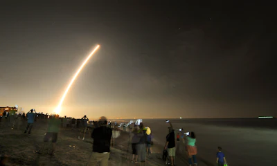 Cell phones light up the beaches of Cape Canaveral and Cocoa Beach, Fla., north of the Cocoa Beach Pier as spectators watch the launch of the NOAA GOES-R weather satellite, Saturday, Nov. 19, 2016. (Malcolm Denemark/Florida Today via AP)