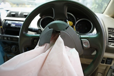 In this Monday, Nov. 7, 2016 photo, the exploded air bag that injured Rabiah binti Ibrahim hangs from the steering wheel in her Honda City in Slim River, Malaysia. Five Malaysians have died in accidents linked to faulty Takata air bags that are at the cen