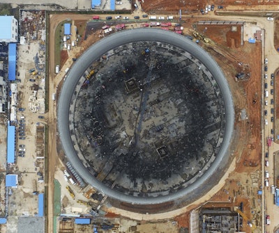 In this aerial photo taken Thursday, Nov. 24, 2016 and released by Xinhua News Agency, rescue workers look for survivors after a scaffolding collapsed during a construction of a circular cooling tower for the Fengcheng power plant in Yichun city in eastern China's Jiangxi Province. (Wan Xiang/Xinhua via AP)