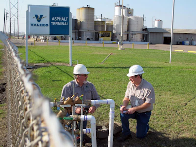 Unidentified men check pipes where Corpus Christi's city-owned water main connects with an asphalt plant where a suspected chemical leak led to a city-wide ban on tapwater use, Saturday, Dec. 17, 2016, in Corpus Christi, Texas. The ban was been gradually eased and city officials expect the results of EPA tests on Sunday to determine it can be fully lifted. (AP Photo/Frank Bajak)