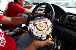 A Honda technician works on an air bag during a free replacement event. (AP Photo/Lim Huey Teng)