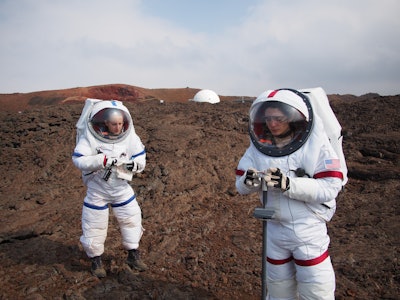 Lucie Poulet, right, uses a geotechnical tool while Annie Caraccio records the data during a previous study outside the domed structure that will house six researchers for eight months in an environment meant to simulate an expedition to Mars, on Mauna Loa on the Big Island of Hawaii. (Sian Proctor/University of Hawaii via AP)