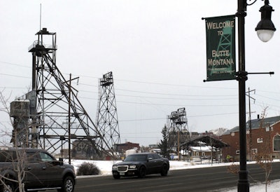 In this Dec. 14, 2016, photo old mining headframes dominate the skyline of Butte, Mont. Residents of the Montana mining city of Butte say the deaths of more than 3,000 snow geese should be a wake-up call for the future of a former open pit mine that is filled with 50 billion gallons of acidic, metal-laden water. (AP Photo/Matt Volz)