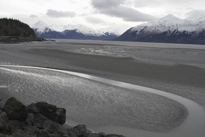 In this March 7, 2016, file photo, a ribbon of water cuts through the mud flats of Cook Inlet, just off the shore of Anchorage, Alaska. (AP Photo/Mark Thiessen, File)