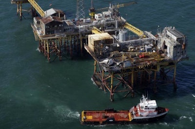 In this Friday, Nov. 16, 2012, file aerial photo, a supply vessel moves near Black Elk Energy's oil platform damaged by an explosion and fire in the Gulf of Mexico about 17 miles from Grand Isle, La. (AP Photo/Gerald Herbert, File)