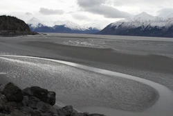 In this March 7, 2016, file photo, a ribbon of water cuts through the mud flats of Cook Inlet, just off the shore of Anchorage, Alaska. Natural gas is bubbling up from an underwater pipeline in Alaska's Cook Inlet, discovered on Feb 7, 2017, when a Hilcorp helicopter spotted bubbles at the surface and reported the leak. State regulators say the danger is minimal but the Coast Guard has issued a warning to mariners and federal wildlife authorities have expressed concern about harm to endangered beluga whales. (AP Photo/Mark Thiessen, File)