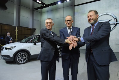Carlos Tavares, left, CEO of PSA Peugeot Citroen, Karl-Thomas Neumann, center, CEO of Opel Group and President of General Motors Dan Ammann, right, shake hands during the press day at the 87th Geneva International Motor Show in Geneva, Switzerland, Tuesday, March 7, 2017. The Motor Show will open its gates to the public from March 9 to 19. (Martial Trezzini/Keystone via AP)