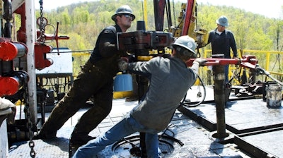 Workers move a section of well casting at a natural gas well site in Pennsylvania. Energy expert Daniel Yergin says that in addition to trucks and traffic, natural gas production can bring jobs and economic growth to gas-rich areas. (Ralph Wilson/AP Photo)