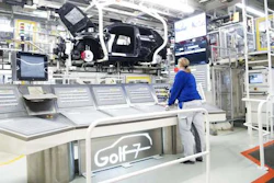 An employee works at the assembly line for Golf 7 cars in the Volkswagen factory in Wolfsburg, Germany. (Julian Stratenschulte/dpa via AP)