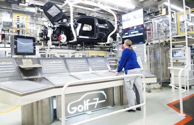 An employee works at the assembly line for Golf 7 cars in the Volkswagen factory in Wolfsburg, Germany. (Julian Stratenschulte/dpa via AP)