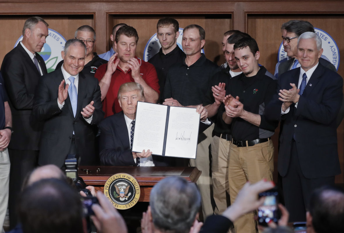 President Donald Trump, accompanied by coal miners and, from left, Interior Secretary Ryan Zinke, Environmental Protection Agency (EPA) Administrator Scott Pruitt, second from right, Energy Secretary Rick Perry, and Vice President Mike Pence, far right, holds up the signed Energy Independence Executive Order, Tuesday, March 28, 2017, at EPA headquarters in Washington. (AP Photo/Pablo Martinez Monsivais)