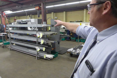 Daniel Bickel, production and operations manager at Nercon, points to a stock rack. Following the precepts of lean operations, Nercon has pruned its racks to carry only the stock needed at each location. Photo: David Tenenbaum