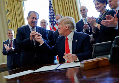 In this Feb. 24, 2017, file photo, President Donald Trump gives the pen he used to sign an executive order to Dow Chemical President, Chairman and CEO Andrew Liveris, as other business leaders applaud in the Oval Office of the White House in Washington. Dow Chemical is pushing the Trump administration to scrap the findings of federal scientists who point to a family of widely used pesticides as harmful to about 1,800 critically threatened or endangered species. Liveris is a close adviser to President Donald Trump. The company gave $1 million for Trump’s inaugural activities.(AP Photo/Pablo Martinez Monsivais, File)
