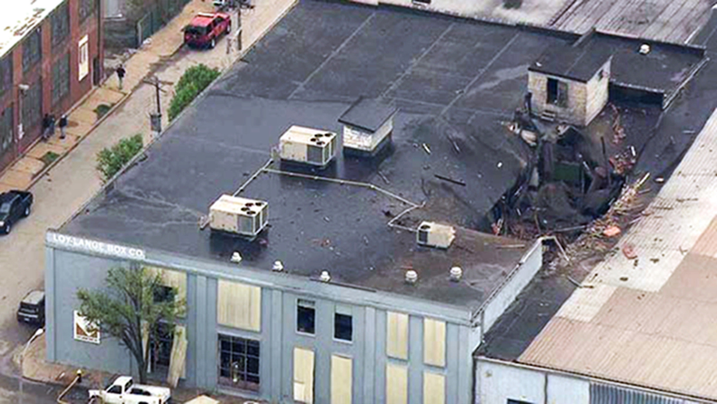 This April 3 photo from video provided by KMOV shows damage to the roof of a box company in St. Louis after a boiler exploded and flew before crashing through the roof of a nearby laundry business. Authorities said several people were killed as a result of the explosion. (KMOV via AP)