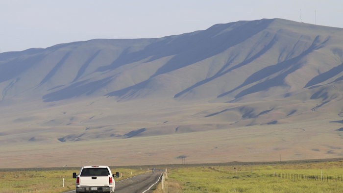 A vehicle drives by the hillsides neighboring the Hanford Nuclear Reservation in Benton County, Tuesday, May 9, 2017, in Washington state. A portion of an underground tunnel containing rail cars filled with radioactive waste collapsed at a sprawling storage facility in a remote area of Washington state, forcing an evacuation of some workers at the site that made plutonium for nuclear weapons for decades after World War II. (AP Photo/Manuel Valdes)