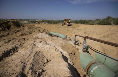 In this Sept. 7, 2014 photo, new pipelines to carry gas from Texas to Mexico, eventually reaching the city of Guanajuato, are laid underground near General Bravo, in Nuevo Leon state, Mexico. In Mexico's Puebla state, gunmen using local residents as a human shield opened fire on a Mexican army patrol investigating fuel pipeline thefts, killing two soldiers and wounding a third, the military said Thursday, May 4, 2017. (AP Photo/Eduardo Verdugo, File)
