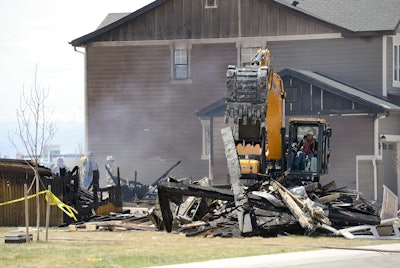 Workers dismantle the charred remains of a house at the location where an unrefined petroleum industry gas line leak explosion killed two people inside their home, in Firestone, Colo., Thursday, May 4, 2017. Fire officials said that an investigation has revealed that the April 17, 2017 explosion was caused by unrefined natural gas that was leaking from a small abandoned pipeline from a nearby well owned. (AP Photo/Brennan Linsley)