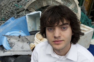 Dutch university dropout Bojan Slat, who founded the The Ocean Cleanup, poses for a portrait next to a pile of plastic garbage prior to a press presentation in Utrecht, Netherlands, Thursday, May 11, 2017. The foundation aiming to rid the world's oceans of plastic says it will start cleaning up the huge patch of floating junk known as the Great Pacific Garbage Patch within the next 12 months, two years ahead of schedule. (AP Photo/Peter Dejong)