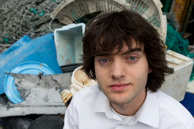 Dutch university dropout Bojan Slat, who founded the The Ocean Cleanup, poses for a portrait next to a pile of plastic garbage prior to a press presentation in Utrecht, Netherlands, Thursday, May 11, 2017. The foundation aiming to rid the world's oceans of plastic says it will start cleaning up the huge patch of floating junk known as the Great Pacific Garbage Patch within the next 12 months, two years ahead of schedule. (AP Photo/Peter Dejong)