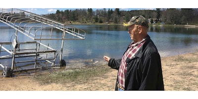 In this April 21, 2017 photo, Cris Van Houten explains how the shoreline of Huron Lake, has receded over the years in Oasis, Wisc. Van Houten and other central Wisconsin lake property owners insist a proliferation of high-capacity wells are draining the region's lakes. (AP Photo/Todd Richmond)