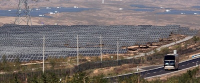 In this file photo taken Saturday, Oct. 10, 2015, a bus moves past by solar power and wind power farms in northwestern China's Ningxia Hui autonomous region. By backing off the U.S. commitment to address climate change, President Donald Trump leaves an opening for a chief economic rival, China, to expand its increasing dominance in the renewable energy industry. In reacting to Trump's announcement that he was withdrawing the U.S. from the Paris climate accord, China reaffirmed its commitment to the landmark agreement and is poised to spend heavily in coming years on renewables. (AP Photo/Ng Han Guan, File)