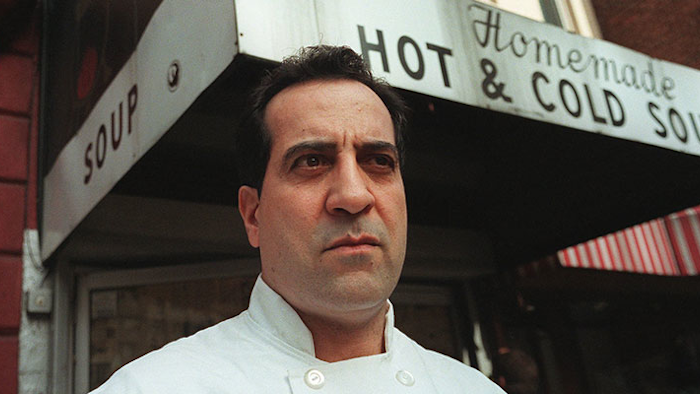 FILE - In this 1997 file photo, Al Yeganeh poses for a photograph outside his business, Soup Kitchen International, in New York. The company that sells soup made with Yeganeh's recipes has filed for bankruptcy less than a month after its chief financial officer was arrested on charges of cheating the government out of employment-related taxes. Yeganeh was the inspiration for the 'Soup Nazi' character on 'Seinfeld' (AP Photo/Michael Schmelling, File)