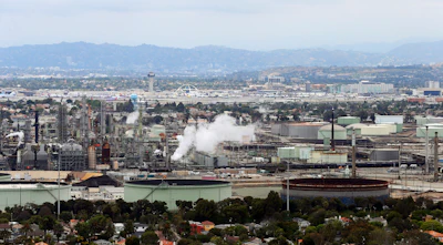 Standard Oil Refinery in El Segundo, Calif., with Los Angeles International Airport in the background and the El Porto neighborhood of Manhattan Beach, Calif., in the foreground. A plan to extend California's cap-and-trade program for another decade looks beyond cutting greenhouse gas emissions and takes aim at toxic air in the polluted neighborhoods around refineries and factories. (AP Photo/Reed Saxon, File)
