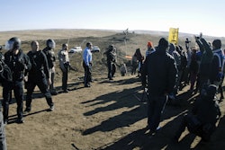 In this Nov. 11, 2016, file photo, law enforcement try to move Dakota Access pipeline protesters further down during a protest at a pipeline construction site south of St. Anthony, N.D. The Trump administration has denied a request from Republican North Dakota Gov. Doug Burgum for a 'major disaster declaration' to help cover some of the estimated $38 million cost to police protests of the pipeline. (Mike McCleary/The Bismarck Tribune via AP, File)
