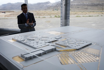 In this April 13, 2016 file photo, Nevada Gov. Brian Sandoval looks at a model for a Faraday Future factory in North Las Vegas, Nev. Electric car maker Faraday Future said Monday, July 10, 2017 that it is deserting its plan to construct a $1 billion manufacturing plant in southern Nevada eight months after suspending the project and sinking at least $120 million into it. (AP Photo/John Locher, File)