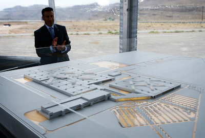 In this April 13, 2016 file photo, Nevada Gov. Brian Sandoval looks at a model for a Faraday Future factory in North Las Vegas, Nev. Electric car maker Faraday Future said Monday, July 10, 2017 that it is deserting its plan to construct a $1 billion manufacturing plant in southern Nevada eight months after suspending the project and sinking at least $120 million into it. (AP Photo/John Locher, File)