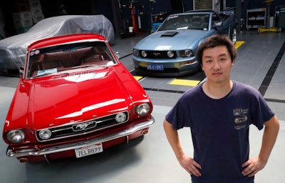 Former race car driver Guo Xin with his 1966 MT GT Fastback and 2005 GT convertible at his garage in Beijing (AP photo)