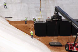 In this June 6, 2013 file photo, crews from Waste Control Specialists load the first of two containers with low-level radioactive waste from Los Alamos National Laboratory in New Mexico, into a reinforced 8-inch-thick concrete container at the 90-acre federal dump where it will remain forever, near Andrews, Texas. (AP Photo/Betsy Blaney)