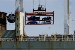 In this July 13, 2017 file photo, a crane transporting vehicles operates on a container ship at the Port of Oakland, in Oakland, Calif. A key draw for foreign assembly plants and investment has been Mexico's low wages. With many workers unable to afford the vehicles Mexico produces, the country exports about three times as many cars as are purchased domestically, most to the United States. (AP Photo/Ben Margot, File)