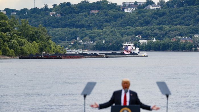 A coal barge is positioned as a backdrop behind President Donald Trump as he speaks during a rally at the Rivertowne Marina in Cincinnati. President Donald Trump personally promised to activate emergency legal authorities to keep dirty or economically uncompetitive coal plants from shutting down, a top American coal company said. The Trump administration now says it has no plans to do so. (AP Photo/John Minchillo, File)