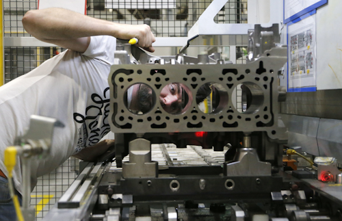 A Ford employee quality checks cylinder holes of a two liter diesel engine, at the Ford Dagenham diesel engine plant in London, Friday, July 21, 2017. Ford’s Dagenham diesel engine plant is a marvel of mechanization _ a steel and chrome hangar full of LED lighting, robots and computer-controlled machine tools. The U.S. carmaker has invested $2.5 billion in the plant, where 3,150 people churn out an engine every 30 seconds. (AP Photo/Frank Augstein)