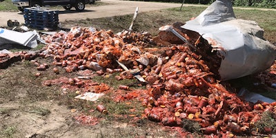 In this Monday, Aug. 21, 2017, photo provided by the Camden News, broken jars of spaghetti sauce litter a road near Camden, Ark. The crash marked the third time this month that edible goods were left on an Arkansas highway. A tanker spilled bourbon on Interstate 40 in eastern Arkansas on Aug. 2, and on Aug. 9 a truck split open on Interstate 30 in Little Rock, spilling frozen pizza. (Shantelle Laughlin/Camden News via AP)