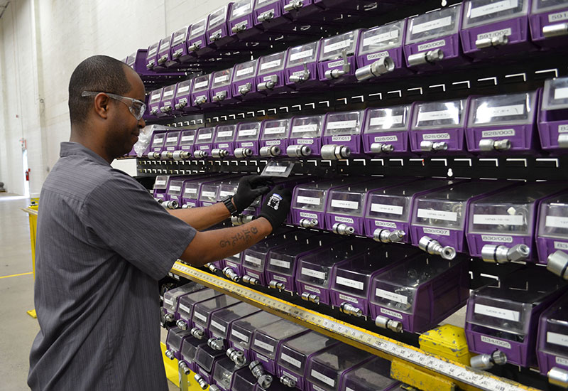 A worker selects a part to complete work on a hose assembly at the RayBuilt Center of Excellence. (Raymond Photo)