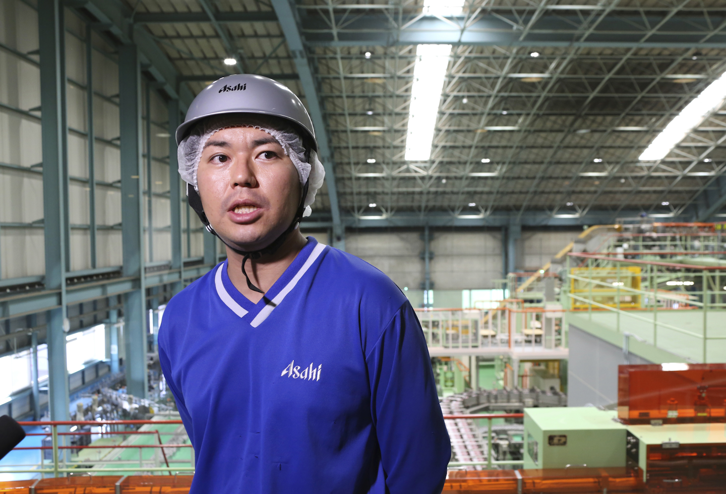 In this Monday, May 29, 2017 photo, Asahi Breweries plant manager Shinichi Uno speaks during an interview nearby the production line at a factory in Moriya near Tokyo. The machines do all the heavy-lifting at this plant run by Japan’s top beer-maker. The human job is to make sure the machines do the work right, and to check on the quality the sensors are monitoring. “Basically, nothing goes wrong. The lines are up and running 96 percent,” says Uno. “Although machines make things, human beings oversee the machines.” (AP Photo/Koji Sasahara)