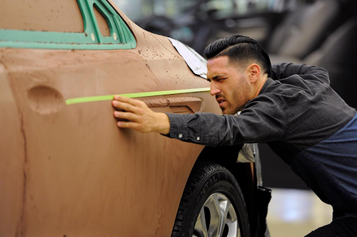 General Motors senior creative exterior designer Maxwell Sullivan sights a line on a model of a 2018 Buick Enclave frame, Friday, Aug. 25, 2017 at the GM Tech Center in Warren, Mich. (AP Photo/Jose Juarez)