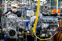 In this Aug. 2, 2017, photo, a Nissan Motor Co. factory worker checks an engine on an assembly line at its plant in Yokohama, near Tokyo. (AP Photo/Shizuo Kambayashi)