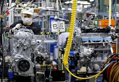 In this Aug. 2, 2017, photo, a Nissan Motor Co. factory worker checks an engine on an assembly line at its plant in Yokohama, near Tokyo. (AP Photo/Shizuo Kambayashi)