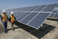 In this Thursday, Aug. 17, 2017, file photo, solar tech Joshua Valdez, left, and senior plant manager Tim Wisdom walk past solar panels at a Pacific Gas and Electric Solar Plant, in Dixon, Calif. Higher energy costs led to prices at the wholesale level rising in August 2017 at the fastest pace in four months, according to information released Wednesday, Sept. 13, 2017, by the Labor Department. (AP Photo/Rich Pedroncelli, File)