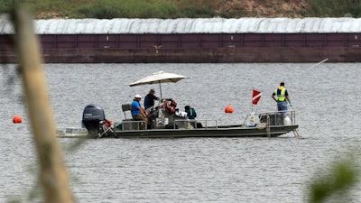 A boat with a dive flag is shown at San Jacinto River Waste Pits near the Interstate 10 bridge over the river in Channelview, Texas. The Environmental Protection Agency says an unknown amount of a dangerous chemical linked to birth defects and cancer may have washed downriver from a Houston-area Superfund site during the flooding from Hurricane Harvey. (AP Photo/David J. Phillip)