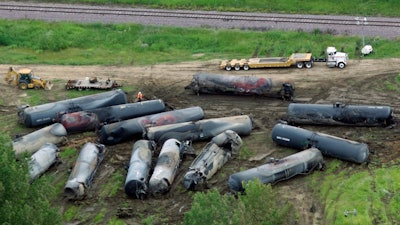 In this June 21, 2009 file photo, railroad freight cars are destroyed after a fiery explosion that killed one person are next to the train tracks following a derailment June 19 in Rockford, Ill. A new report says more and better inspections of freight railroad tracks and greater training for emergency workers are needed to address the continuing risk of fiery oil and ethanol train crashes. (AP Photo/Rockford Register Star, Scott Morgan, File)