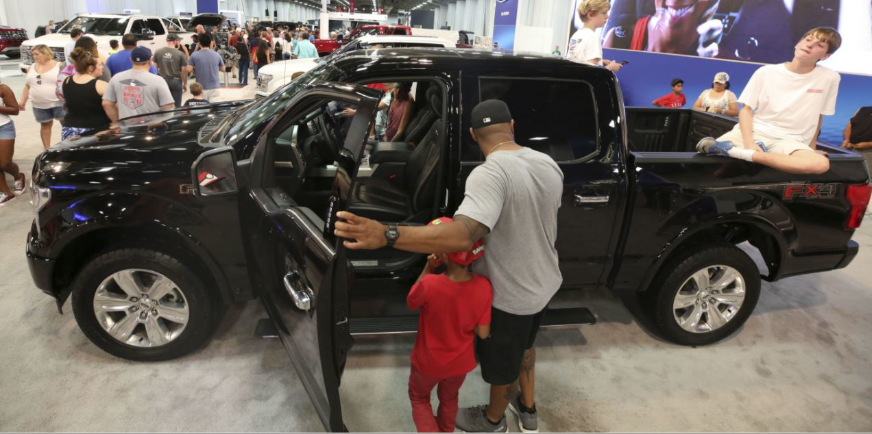 Fairgoers look at pickup trucks on display at the State Fair of Texas (AP photo)