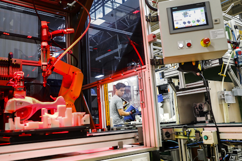 In this Thursday, May 25, 2017, file photo, an assembly line laborer works alongside a collaborative robot, left, on a chainsaw production line at the Stihl Inc. production plant in Virginia Beach, Va. On Tuesday, Oct. 17, 2017, the Federal Reserve reports on U.S. industrial production for September. (AP Photo/John Minchillo, File)