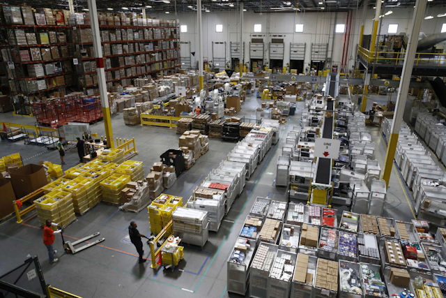 Workers prepare to move products at an Amazon fulfillment center in Baltimore. While jobs have been lost in brick-and-mortar stores, many more have been gained from e-commerce and warehousing. Amazon accounts for much of the additional employment. (AP Photo/Patrick Semansky)
